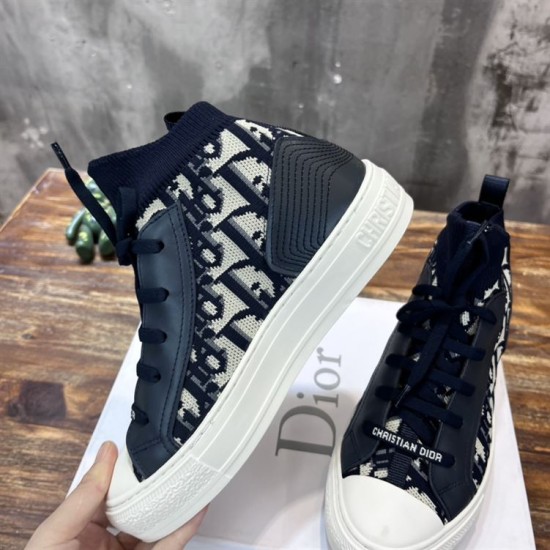 Side elevation of Dior Walk'n'Dior dark blue oblique trainer held in hand