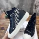 Side elevation of Dior Walk'n'Dior dark blue oblique trainer held in hand