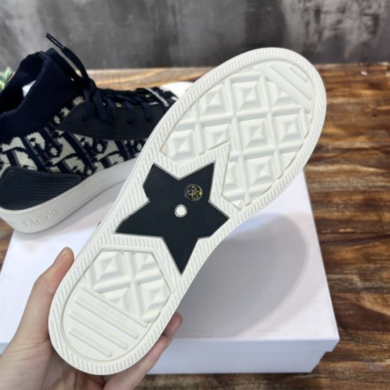 Underside view of off-white rubber sole featuring black star insert on Dior trainer in dark blue