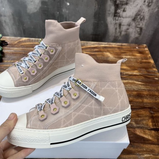 Pair of Dior Walk'n'Dior high-top knit pink trainers resting on a wooden surface beside product box