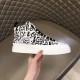 Hand holding single Dolce & Gabbana Portofino Light Canvas Logo Print Mid-Top Trainer showing outer side profile in white and black