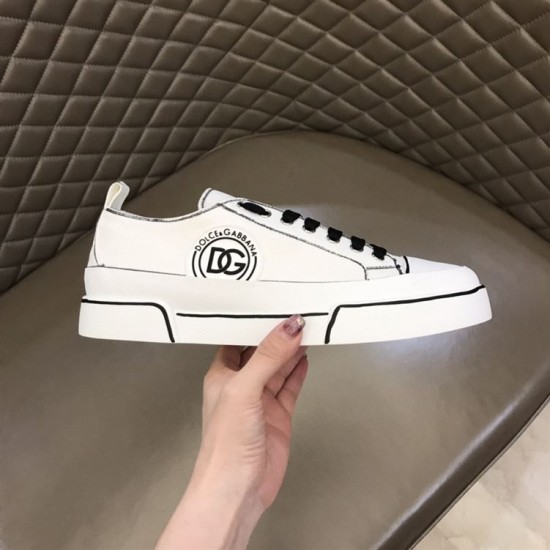 Lateral side view of white Dolce & Gabbana Portofino Light canvas trainer held by hand in white and black