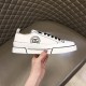 Lateral side view of white Dolce & Gabbana Portofino Light canvas trainer held by hand in white and black