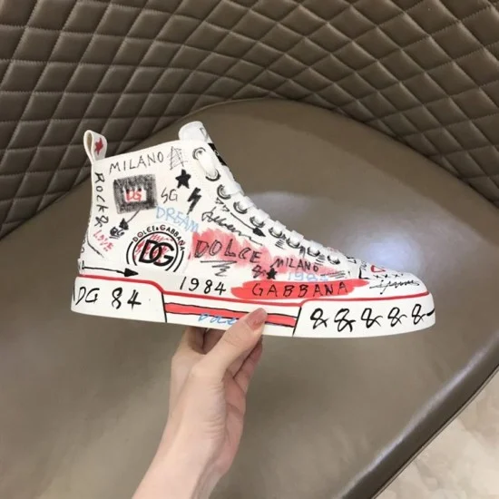 Dolce & Gabbana Graffiti Canvas Mid-Top Trainers Handheld Profile in white Dolce & Gabbana white hand-painted trainer held to highlight lateral side artwork and sole