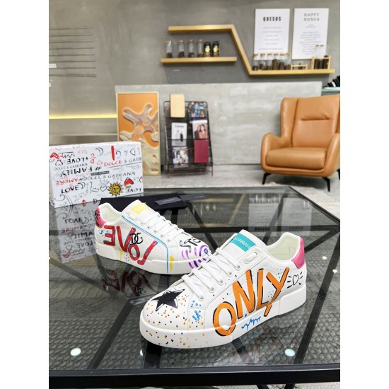 Angled perspective of Dolce & Gabbana Portofino Graffiti Print White Leather Trainers on glass table in white and red