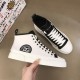 Angled top-down view showing both shoes of the Dolce & Gabbana white mid-top trainer set