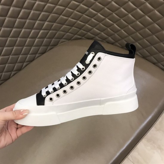 Medial side view of white Dolce & Gabbana mid-top canvas trainer held by hand