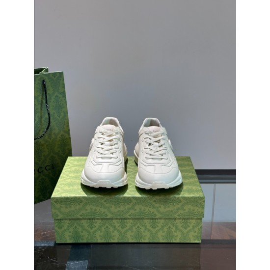 Front view pair of off-white leather trainers sitting on green box
