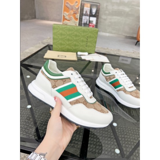 Handheld side profile of Gucci white leather trainer showcasing green and red Web stripe over beige GG canvas