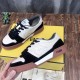 Hand holding a Fendi Match black and off-white suede trainer above packaging