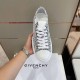 Hand holding a single Givenchy City 4G jacquard trainer in black and white from above