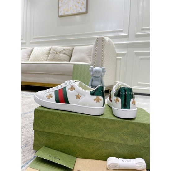 Rear angle showing metallic green snakeskin heel tabs on white leather trainers
