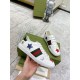 Hand holding single Gucci Ace Embroidered white leather trainer showing side web stripe and metallic star patches in white and green