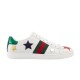 Side profile view of Gucci Ace Embroidered Leather Low Top Trainers in white featuring green and red web stripe with metallic stars.