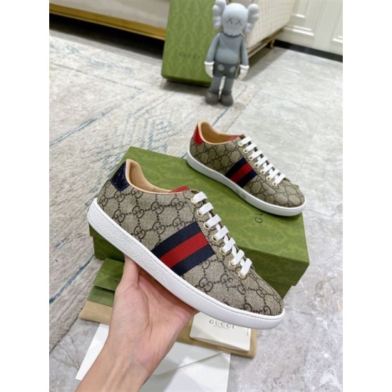 Gucci Ace GG Supreme Canvas Web Stripe Trainers Handheld View in beige and brown Hand holding Gucci Ace GG Supreme Canvas Web Stripe Trainers in beige and brown monogram canvas