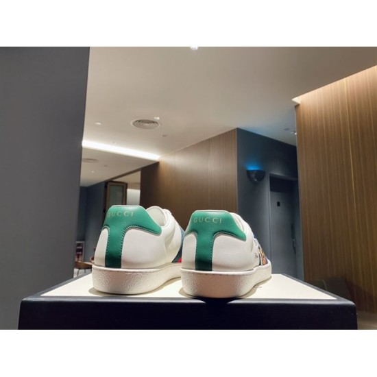 Rear view showing green heel tabs on white Gucci Ace Donald Duck trainers