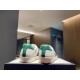 Rear view showing green heel tabs on white Gucci Ace Donald Duck trainers
