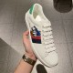 Handheld top-down view of white Gucci Ace Donald Duck leather trainer
