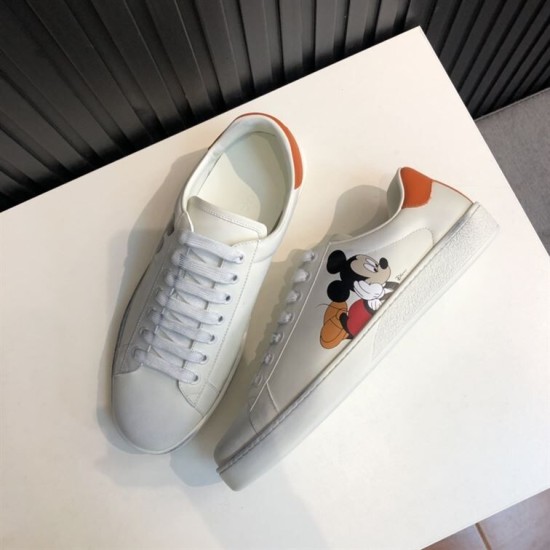 Gucci Ace Disney Mickey Mouse Ivory Trainers Pair View in ivory and orange Top-down perspective of pair of Gucci Ace Disney Mickey Mouse ivory leather trainers on a white surface in ivory and orange