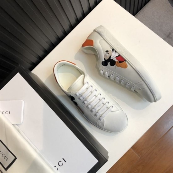 Gucci Ace Disney Mickey Mouse Ivory Trainers Packaging View in ivory and orange Angled view of Gucci Ace Disney Mickey Mouse ivory trainers beside shoe box packaging in ivory and orange