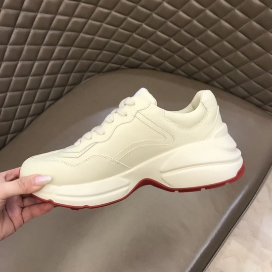 Gucci Rhyton Ivory Trainer Medial View in ivory and red Hand holding Gucci Rhyton ivory trainer showing medial side construction and red outsole border