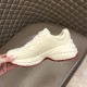 Gucci Rhyton Ivory Trainer Medial View in ivory and red Hand holding Gucci Rhyton ivory trainer showing medial side construction and red outsole border