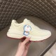 Gucci Rhyton Ivory Trainer Lateral Detail in ivory and red Hand holding Gucci Rhyton ivory trainer showing lateral character print and thick midsole in ivory and red