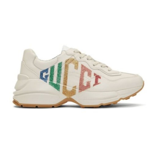 Gucci Rhyton Ivory Rainbow Glitter Trainers Lateral View Full lateral side view of Gucci Rhyton ivory trainers with rainbow glitter logo