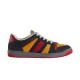 Gucci Screener Trainers In Black Suede And Orange Profile Lateral side view of black suede and orange Gucci Screener trainer against a plain backdrop.