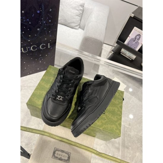 Pair of Gucci low top black leather trainers set on green box