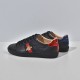 Gucci Men's Ace Bee Embroidered Black Leather Trainers - Heel Detail View Rear side view of Gucci Men's Ace Bee Embroidered Black Leather Trainers highlighting red and blue metallic heel tabs