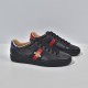Gucci Men's Ace Bee Embroidered Black Leather Trainers - Three-Quarter Angle Angled front view of Gucci Men's Ace Bee Embroidered Black Leather Trainers displaying the gold bee embroidery