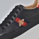 Gucci Men's Ace Bee Embroidered Black Leather Trainer - Bee Embroidery Close-Up Close-up of the gold bee embroidery and web stripe on the Gucci Men's Ace Bee Embroidered Black Leather Trainer