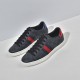 Angled front view of pair of Gucci Ace GG Supreme black trainers