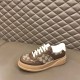 Gucci GG Supreme Brown Trainer Single View in brown and white Single Gucci GG Supreme brown leather trainer resting on a plush padded bench in brown and white
