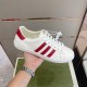 Gucci White Leather Trainer Close Up in white and red Hand holding Gucci white leather low-top trainer highlighting side stripes in white and red