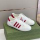 Gucci Low Top Trainers Front Angle in white and red Angled view of a pair of Gucci white trainers with red stripes on a green box.
