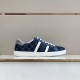Gucci Men's GG Blue Denim Trainer Lateral View Side view of Gucci Men's GG Blue Denim Low-Top Trainer displayed on a store shelf