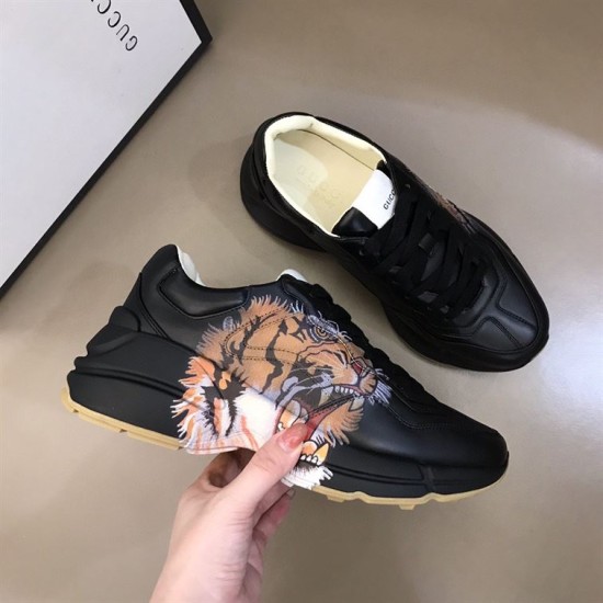 Gucci Rhyton Tiger Print Leather Trainer Printed Detail View in black Hand holding Gucci Rhyton black trainer showing printed tiger face