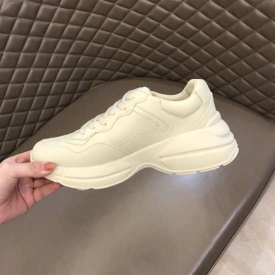 Gucci Rhyton Ivory Trainer Medial Side View in ivory and red Hand holding inner medial side of Gucci Rhyton ivory plain leather upper in ivory and red