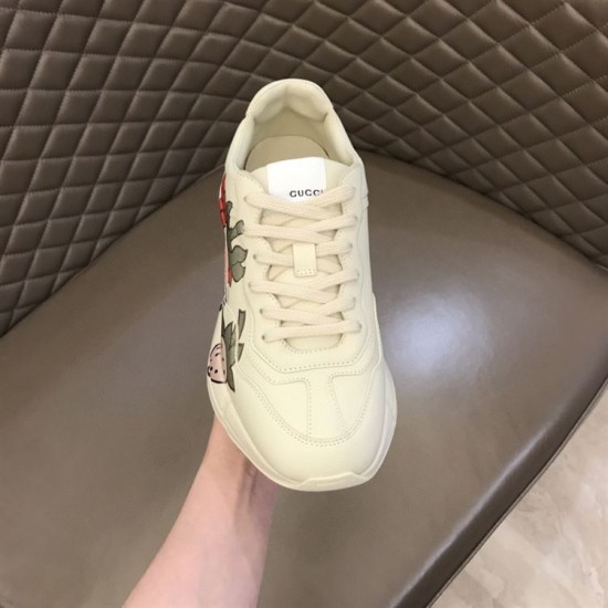 Gucci Rhyton Trainer Front Perspective View in ivory and red Front upper perspective view of Gucci Rhyton ivory trainer showing tongue logo in ivory and red