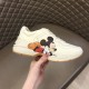 Gucci x Disney Rhyton Trainer Lateral Profile in ivory Hand holding Gucci x Disney Rhyton trainer displaying lateral graphic in ivory