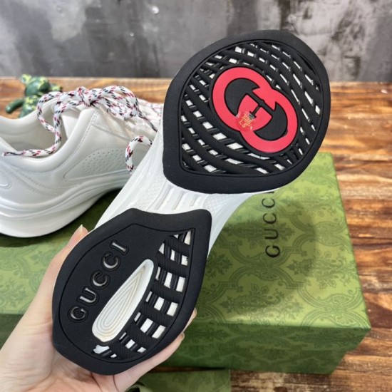 Underside view of black and white rubber outsole with red logo accent