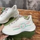 Side view of white trainer with pink and mint stripe detail held by hand