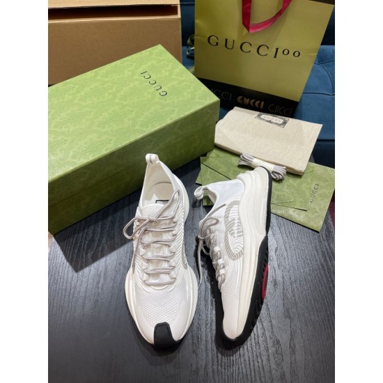 Pair of White Gucci Run Knit Trainers with Packaging Pair of white Gucci Run knit trainers angled on a table next to branded packaging