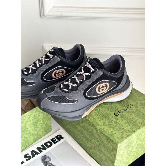 Angled front shot of grey and black Gucci trainers with patterned laces