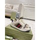 Gucci Screener Beige Low Top Trainers - Three-Quarter Angle Three-quarter view of beige Gucci Screener trainers resting on a green branded shoebox