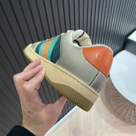 Gucci Screener Trainers Heel Detail in beige and green Close-up of orange leather heel tab and textured rubber sole on Gucci Screener trainer in beige and green