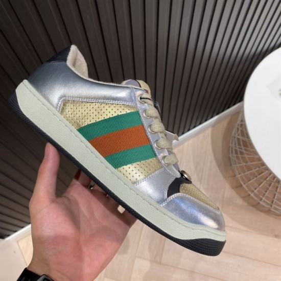 Gucci Screener Metallic Silver Gold Web Stripe Leather Trainers Lateral Side Hand holding Gucci Screener Metallic Silver Gold Web Stripe Leather Trainers lateral side