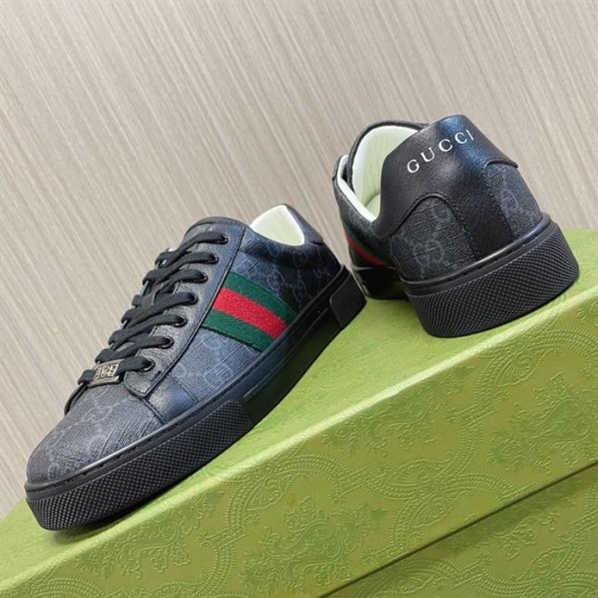 Gucci Black Monogram Web Trainers - Angle View in black and white Gucci black monogram leather web trainers resting on a green box showing the heel and side detailing in black and white